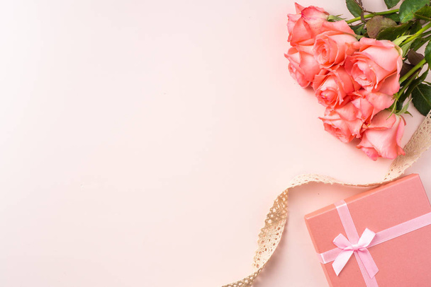 Ramo de rosas rosadas, caja de regalo con cinta sobre fondo rosa
 - Foto, imagen