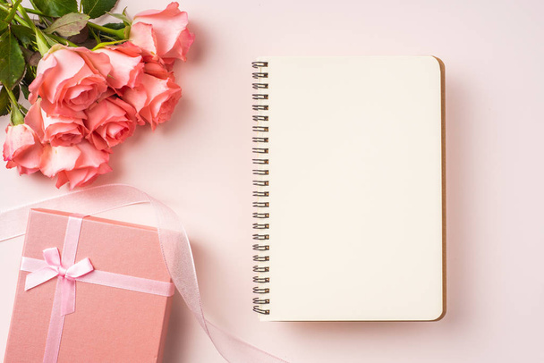 Bouquet of pink roses, gift box, white notebook on pink background - Φωτογραφία, εικόνα