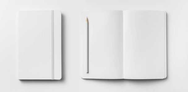 Top view of opened and closed white notebooks with elastic band and wooden pencil isolated on white background for mockup. - Photo, Image