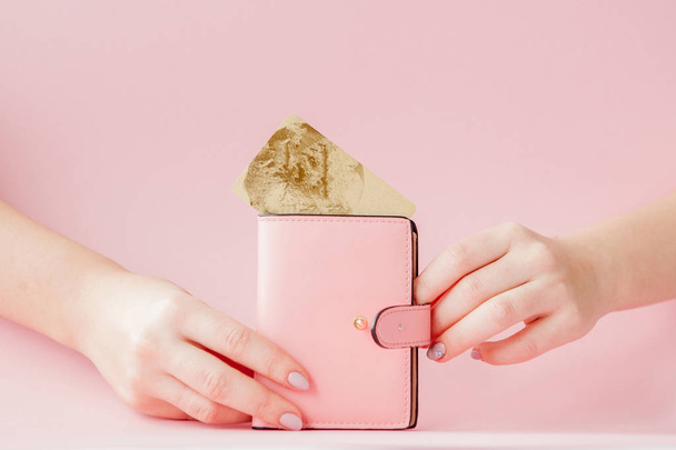 Kyiv, Ukraine - February 22, 2019: wallet and credit card in woman's hand on pink background - Foto, immagini