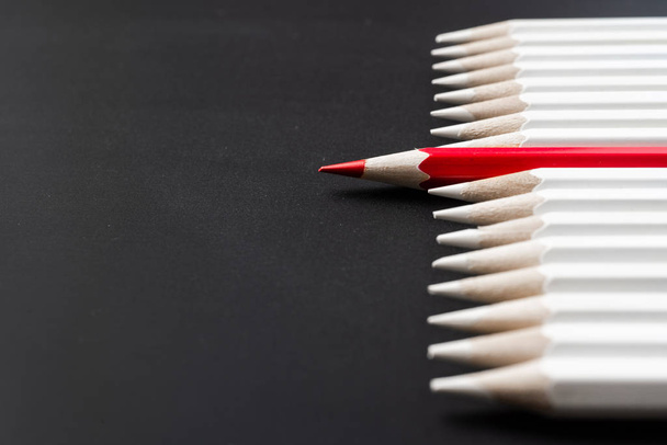 Business and design concept - lot of white pencils and one color pencil on black background. Symbol of leadership, teamwork, success and unique. - Фото, изображение