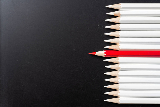 ビジネスとデザインの概念 - 黒の背景に白い鉛筆と1色の鉛筆の多く。リーダーシップ、チームワーク、成功、ユニークなシンボル. - 写真・画像
