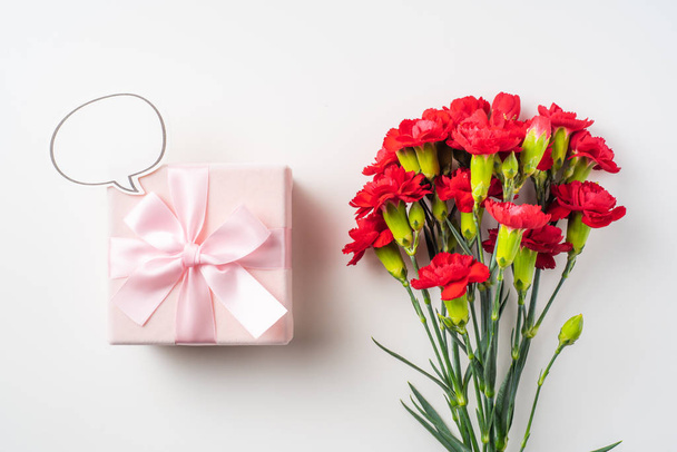 Bouquet of red carnations and gift box on background with copy space - Fotografie, Obrázek
