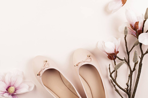 Nude colored ballerina shoes and magnolia flowers. - Zdjęcie, obraz