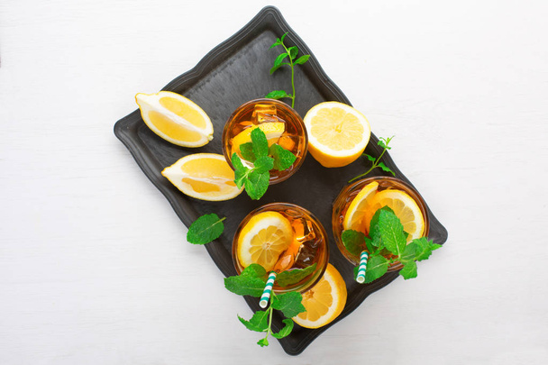 Ijsthee met schijfjes citroen, munt en ijs  - Foto, afbeelding