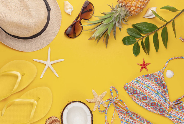Summer vacation, travel, tourism concept flat lay. Tropical beach accessories top view with swimming suit, hat and flip flops - 写真・画像