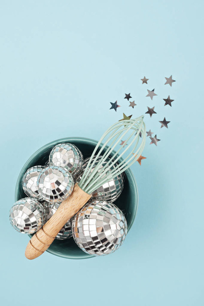 Flat lay with disco balls in the bowl with whisk. Party, fun, celebration planning concept - Photo, Image