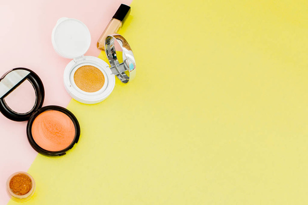 Make up products spilling on to a bright yellow and pink backgro - Foto, Bild