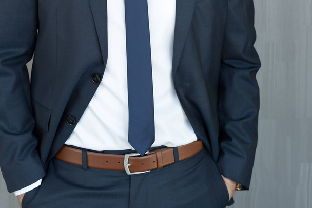 Torso di un uomo d'affari in piedi con le mani serrate in posizione centrale in un classico abito blu navy
. - Foto, immagini