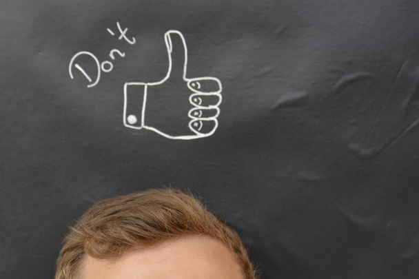 head in front of a board with drawn thumb up  - Photo, Image