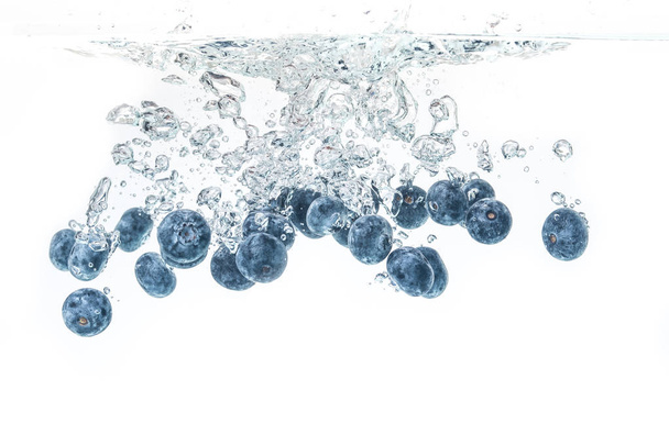 Blueberrys salpicando em água cristalina com bolhas de ar
 - Foto, Imagem