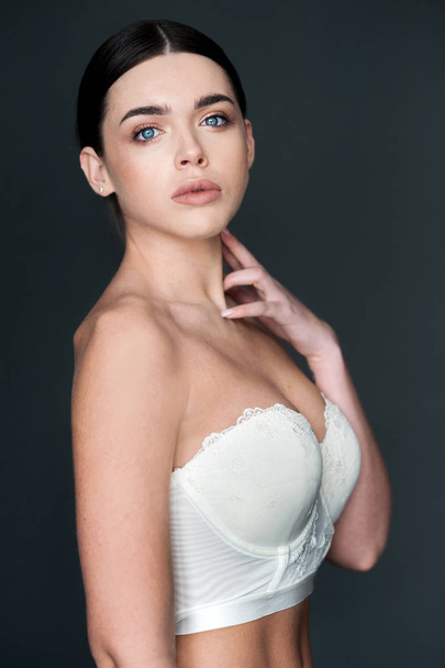Beautiful young female brunette model portrait in lingerie on dark background - Fotografie, Obrázek