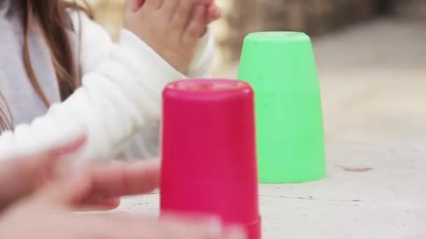 Fiatal lányok játszanak műanyag poharak.  - Felvétel, videó