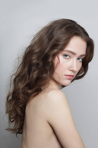 Young beautiful slim girl with long curly hair and clean makeup - Fotografie, Obrázek