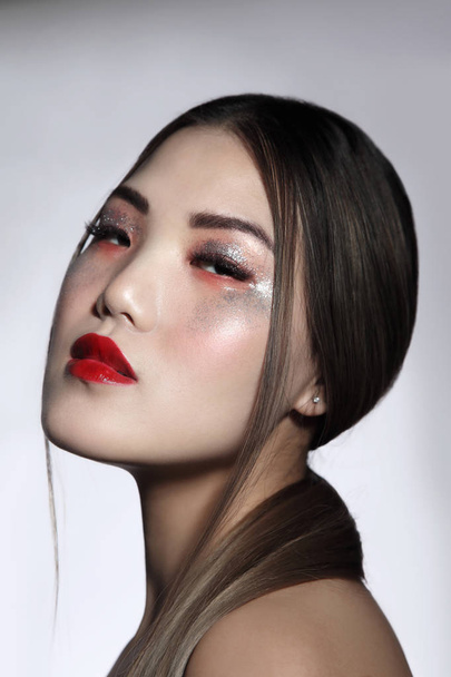 Portrait of young beautiful asian girl with fancy glitter makeup - Fotó, kép