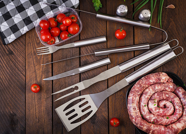 Barbecue Tools and sausage on wooden table. Flat lay, top view - Photo, Image