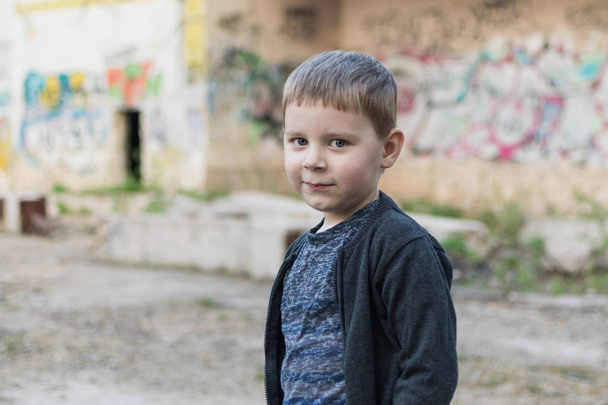 Little boy on brick wall background. - Fotó, kép