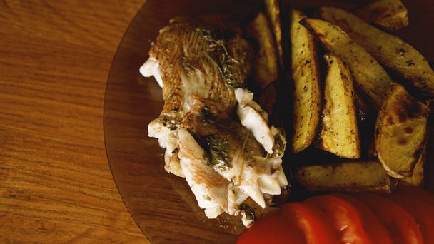 Рыбное блюдо - жареное филе рыбы с жареным картофелем и овощами
 - Фото, изображение