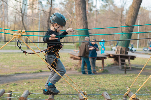 A little boy is passing an obstacle course. Active physical recreation of the child in the fresh air in the park. Training for children. - Photo, Image