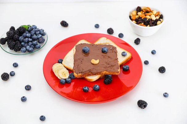 Toast with eyes and a smile. Toast with chocolate and nut paste. - Foto, Imagem