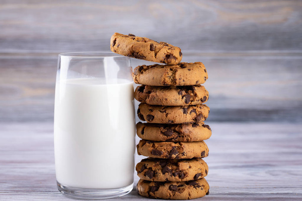 A stack of chocolate chip cookies lies near a glass of milk. Cal - Foto, imagen
