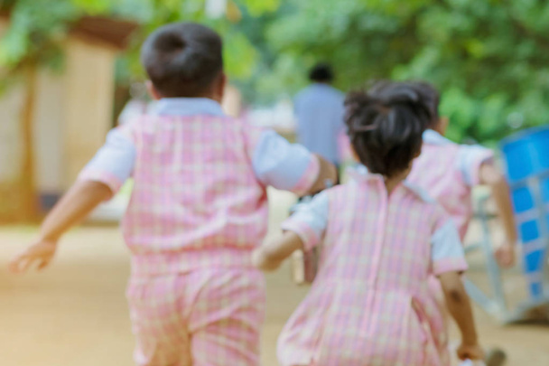 Размытое изображение учеников детского сада бегут обратно в класс после обеда
. - Фото, изображение
