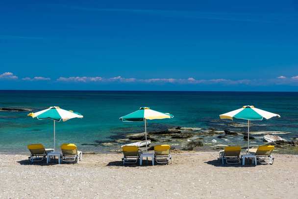 Liegestühle und Sonnenschirm am Strand, am Strand. - Foto, Bild