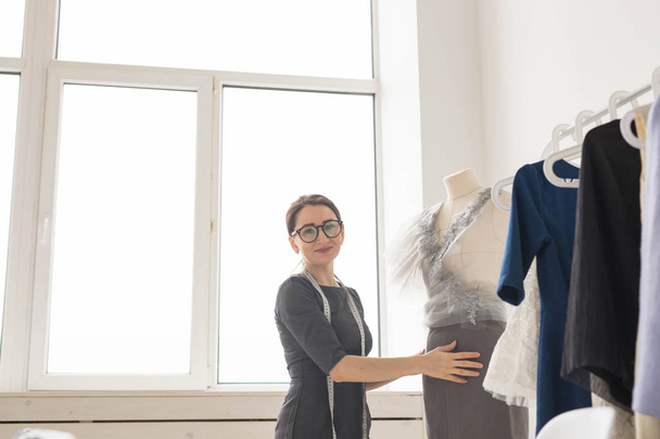 Dressmaker, sastre, moda y concepto de sala de exposición - Retrato de modista mujer talentosa que trabaja con textiles para coser ropa
 - Foto, imagen