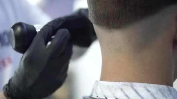 Maschio barbiere utilizzando un talco per giovane cliente in salone
 - Filmati, video