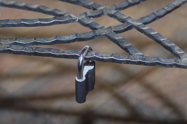 Metal lock, latched on a metal decorative forged lattice. Concept - Foto, Imagen