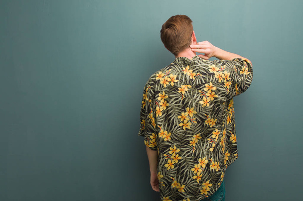 Mladý zrzka muž na sobě exotické letní oblečení zezadu přemýšlet o něčem - Fotografie, Obrázek