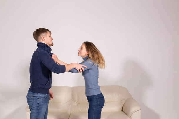 people, violence and abuse concept - young aggressive man hitting his girlfriend in her arm - Photo, Image