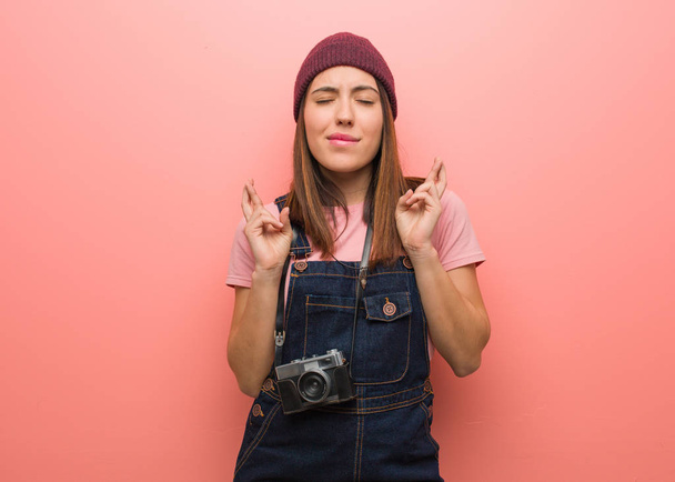 Νεαρή χαριτωμένη φωτογράφος γυναίκα σταυρώνει τα δάχτυλα για την τύχη - Φωτογραφία, εικόνα