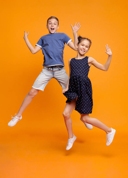 幸せな小さな女の子と男の子が一緒に喜びのためにジャンプ - 写真・画像