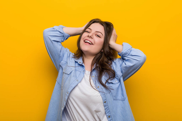 Young curvy plus size woman laughs joyfully keeping hands on head. Happiness concept. - Foto, immagini