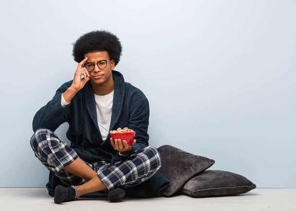 若い黒人の男が座って朝食を考えてる - 写真・画像