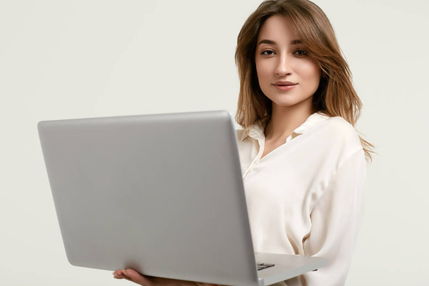 Gorgeous brunette model posing in white clothes with laptop - Photo, Image