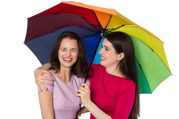 Дві смішні молоді жінки з райдужною парасолькою
 - Фото, зображення