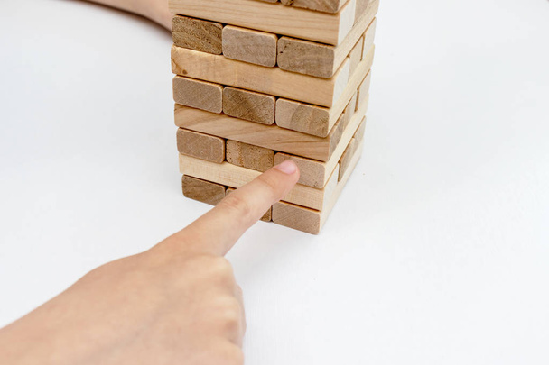 A preteen caucasian boy playing wooden block tower board game for practicing his physical and mental skill and entertainment - Foto, Imagem