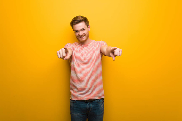 Young redhead man cheerful and smiling pointing to front - Photo, Image