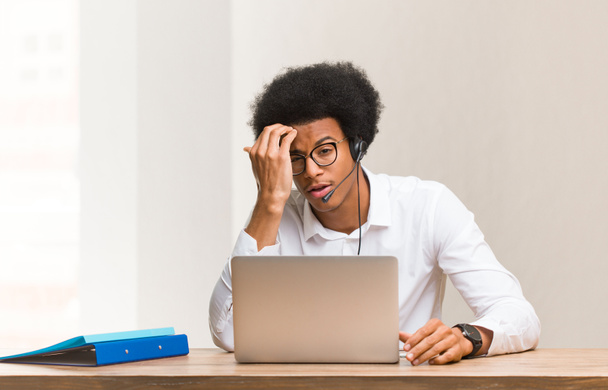 Young telemarketer black man worried and overwhelmed - Fotoğraf, Görsel