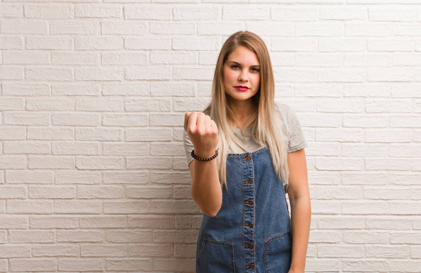 Young russian hipster woman showing fist to front, angry expression - Foto, imagen