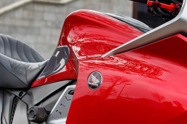 Moscow, Russia - May 04, 2019: Glossy red fuel tank of sports motorcycle with Honda emblem closeup. Moto festival MosMotoFest 2019 - 写真・画像