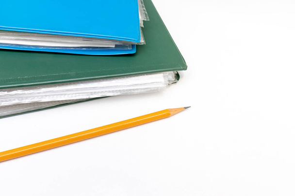 Cropped colorful folders with documents and bills and a yellow pencil on white table with copy space - Фото, изображение