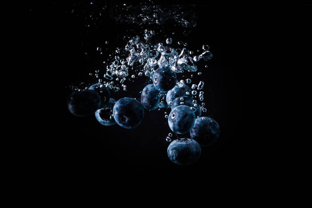 Βατόμουρα που πέφτουν σε ένα μαύρο νερό - Φωτογραφία, εικόνα