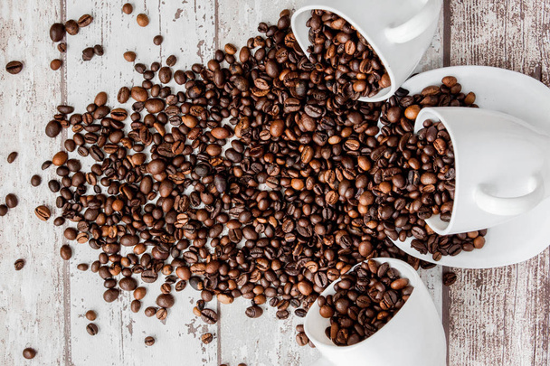 Black coffee in white cup and coffee beans on light wooden backg - Foto, Imagem