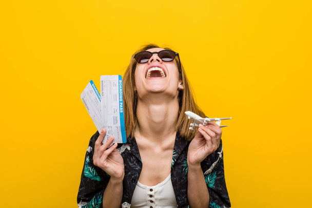 Joven mujer caucásica sosteniendo billetes de avión muy feliz
. - Foto, Imagen