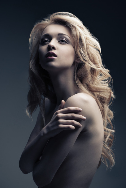 Posing blond woman with long curly hair on black - Φωτογραφία, εικόνα