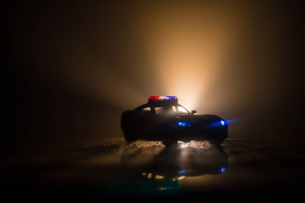 Polizeiautos in der Nacht. Polizeiwagen bei einer nächtlichen Verfolgungsjagd im Nebel. 911 Einsatzwagen der Polizei rasen zum Tatort. Selektiver Fokus - Foto, Bild