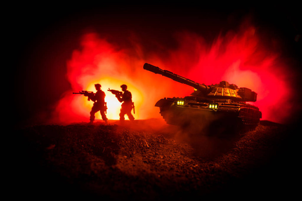 Concept van de oorlog. Militaire silhouetten vechten scène op oorlog mist hemelachtergrond, silhouet van gepantserde voertuig onder bewolkte Skyline At night. Aanval scène. Battle tanks. Illustraties decoratie - Foto, afbeelding